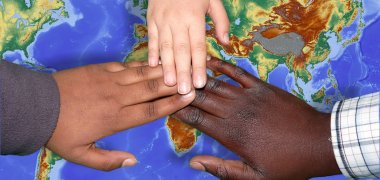 Children's hands over a world map